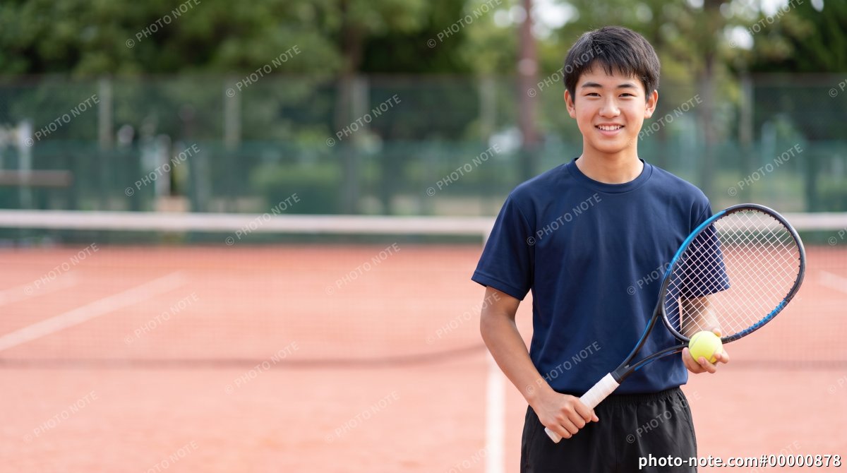 屋外テニスコートでラケットを持ち微笑む男子中高生