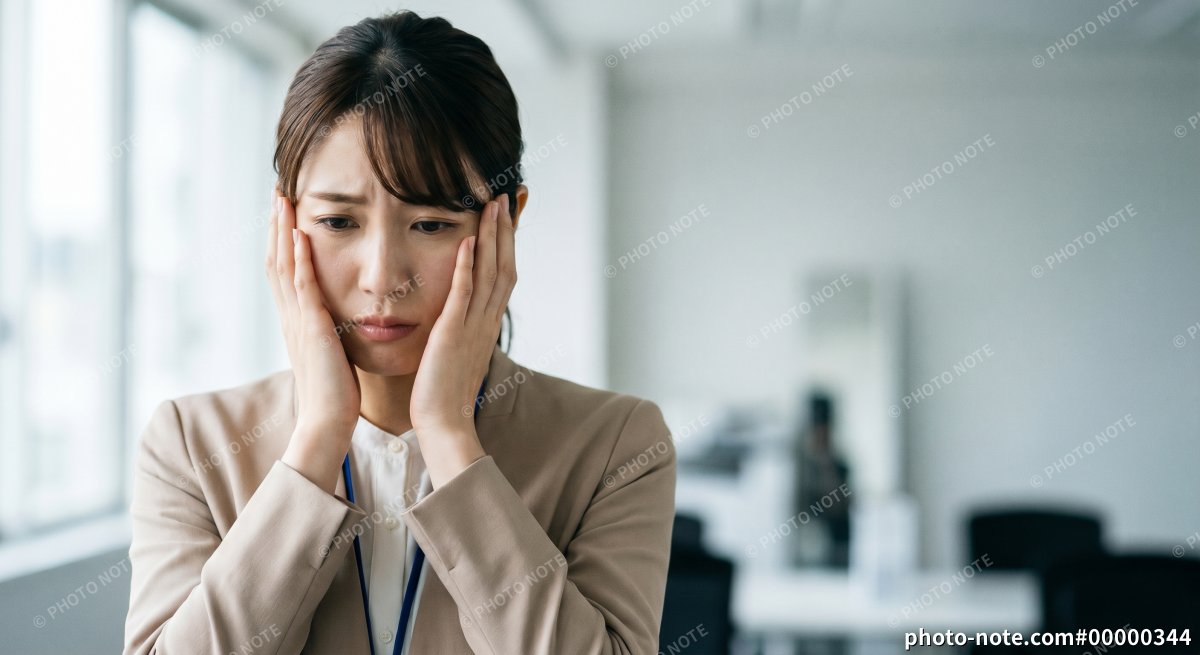 困った表情のスーツ姿の女性