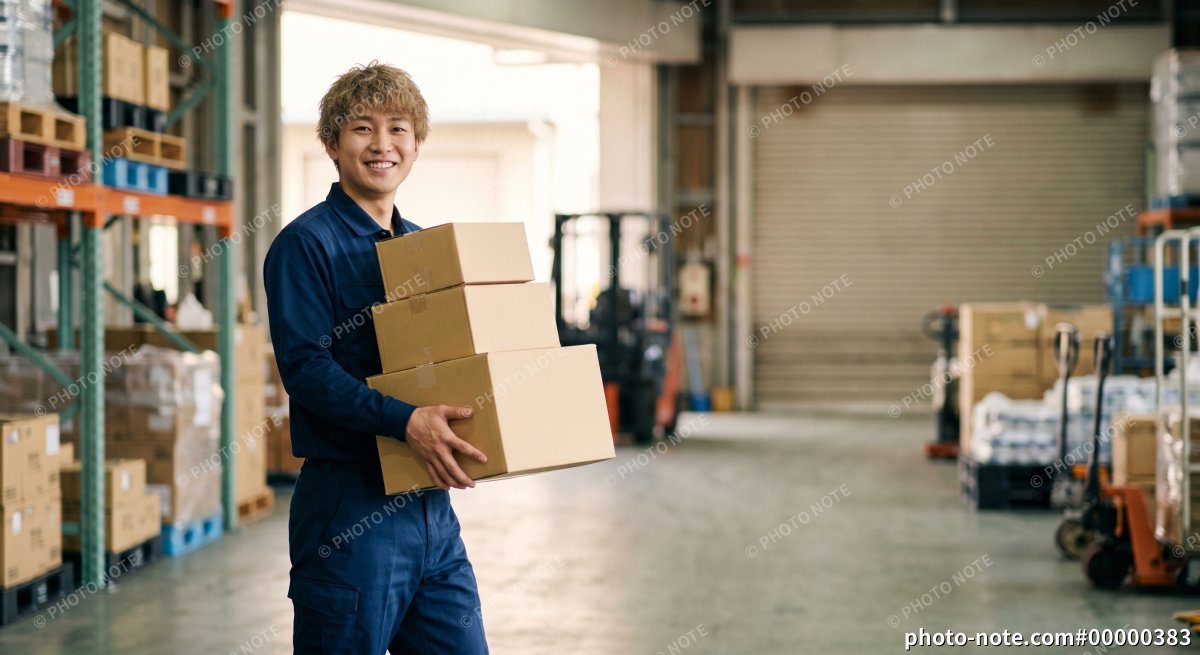 物流倉庫で荷物を運ぶ男性作業員