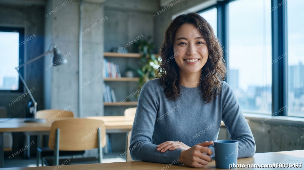 窓際のワークスペースでコーヒーを楽しむ女性