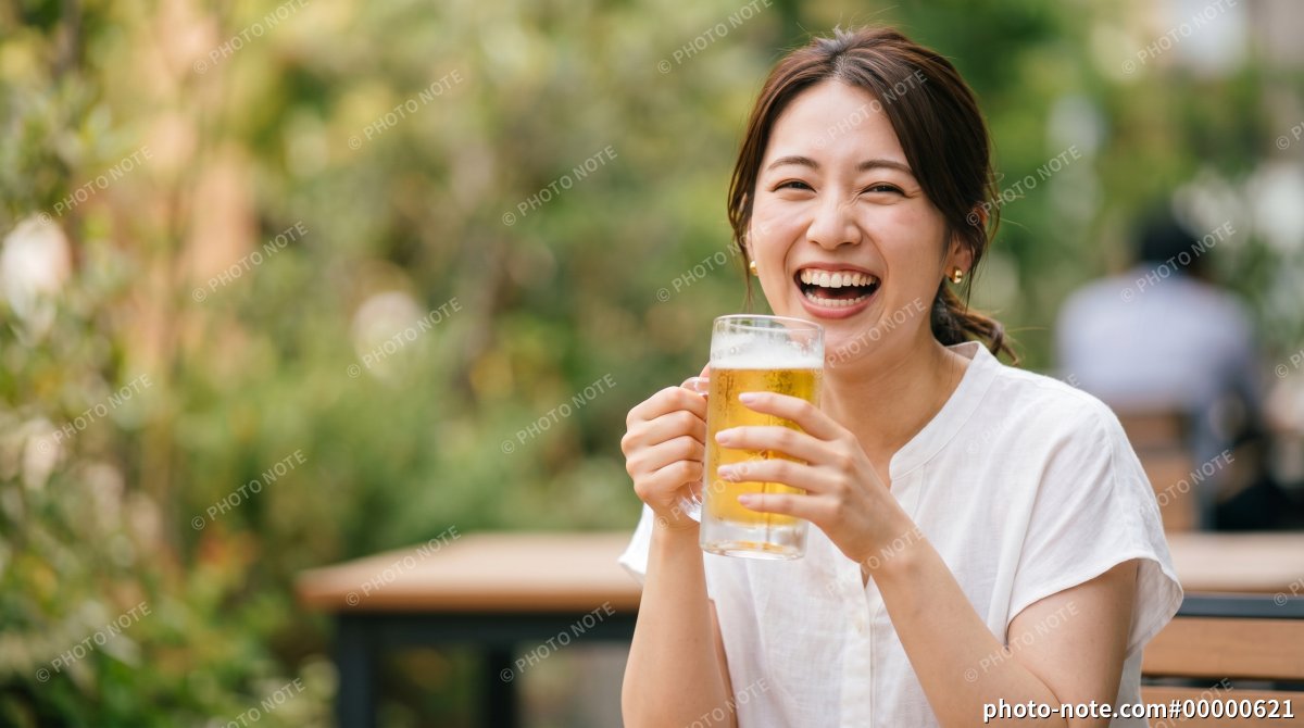屋外で笑顔でビールを飲む女性