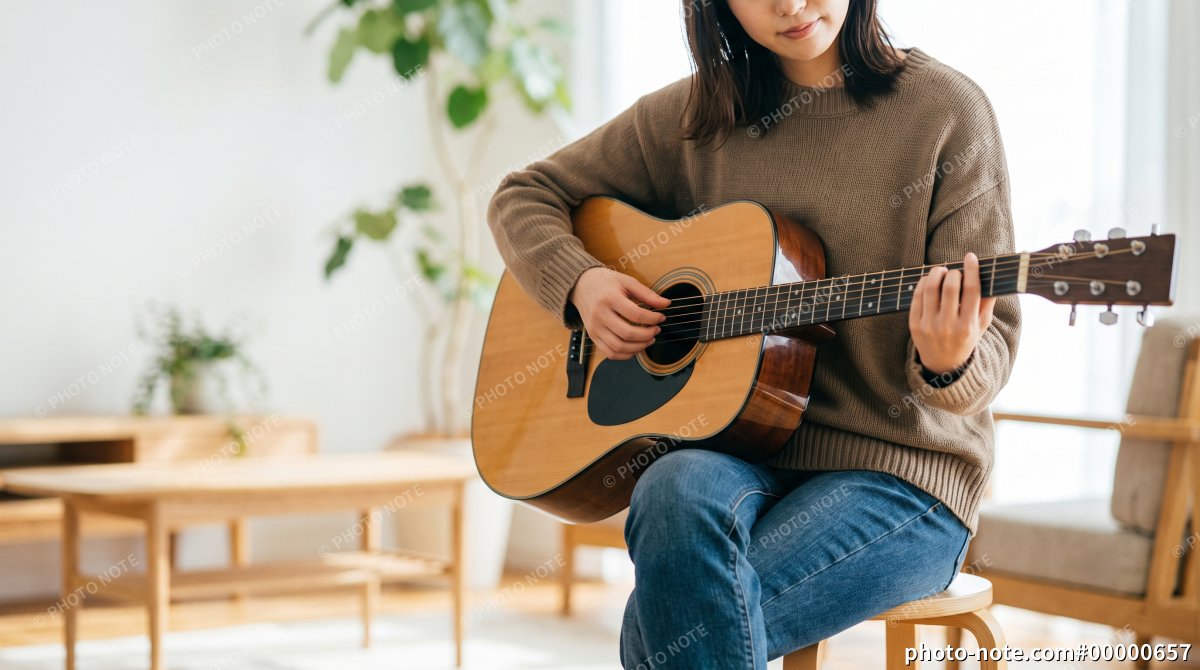 アコスティックギターを弾く女性