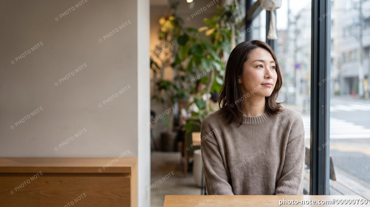 カフェの窓際に座る女性