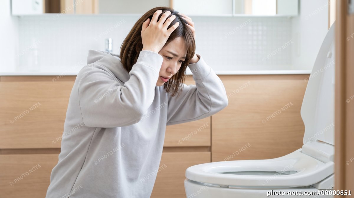 トイレのトラブルに困り頭を抱える女性