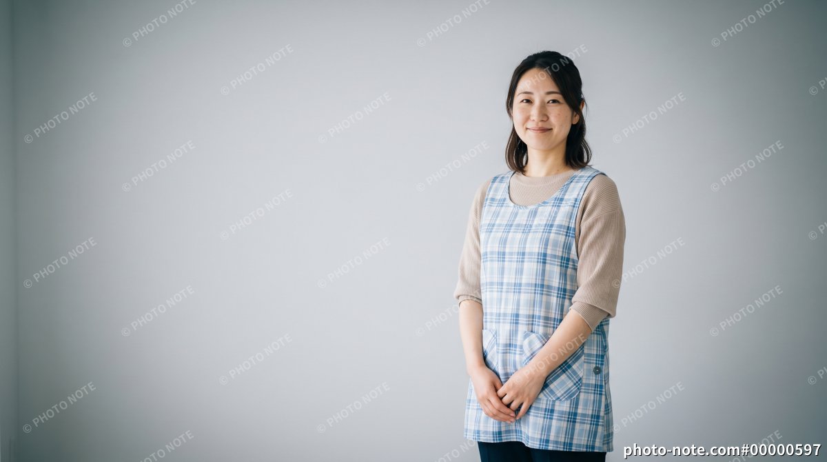 エプロンを着て微笑む若い保育士の女性