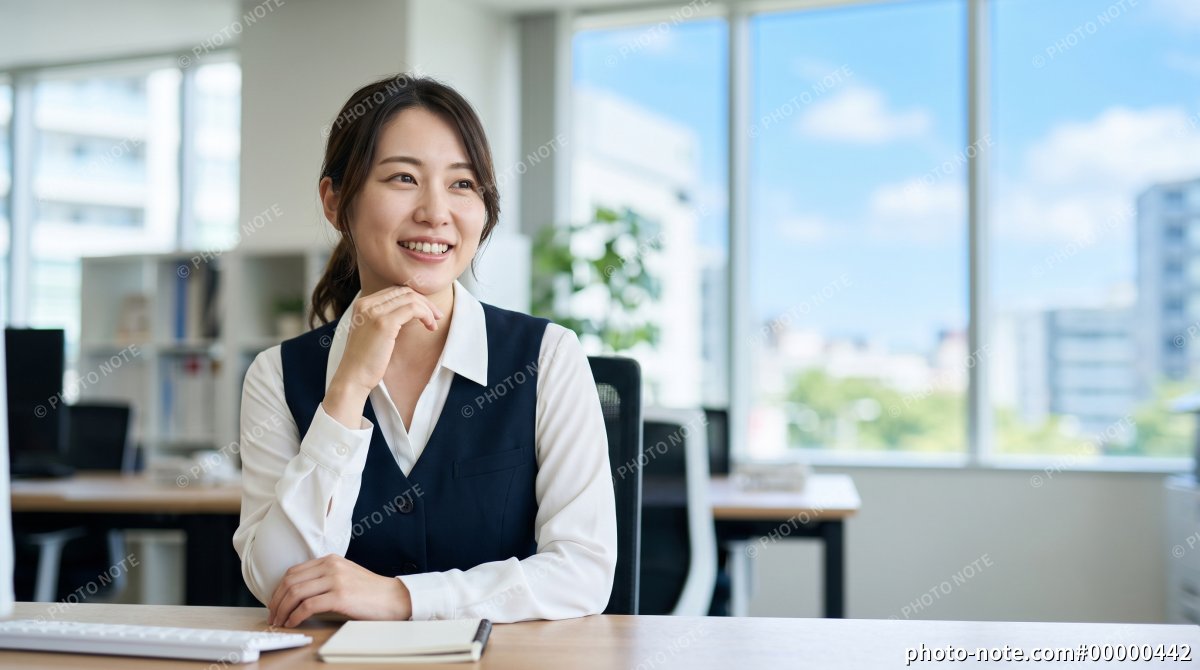企業オフィスで働くリラックスした表情の若い女性スタッフ