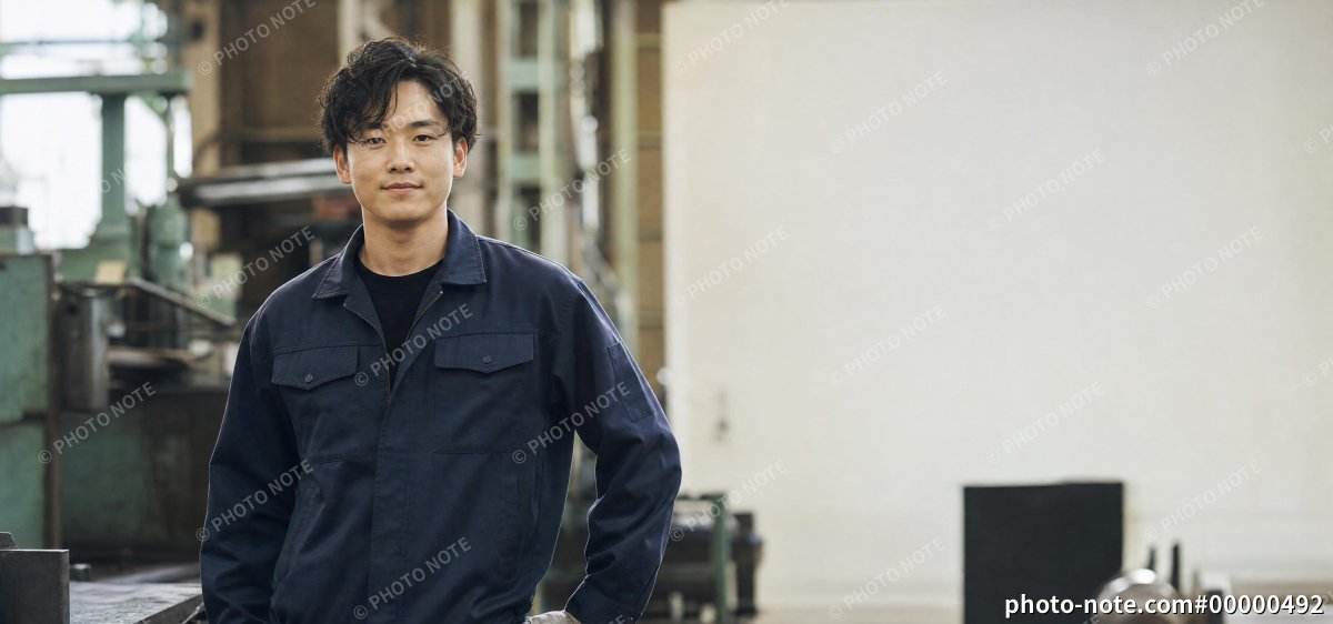 工場で立つ若い男性作業員