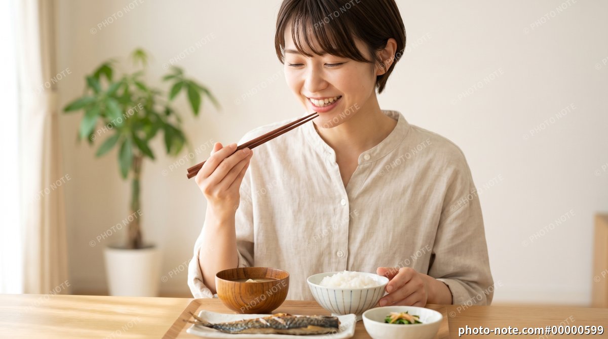 和食の食事を食べる笑顔の若い女性